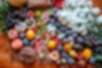 Eye-level view of a colorful spread of fresh fruits and vegetables on a wooden table